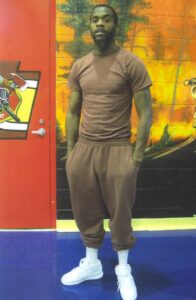 Taunses Robinson standing in front of orange mural